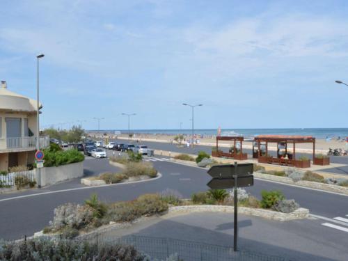 - un parking à côté d'une plage avec un bâtiment dans l'établissement Studio face à la mer, balcon et local à vélo, 300m du centre - Narbonne Plage - FR-1-229B-61, à Narbonne
