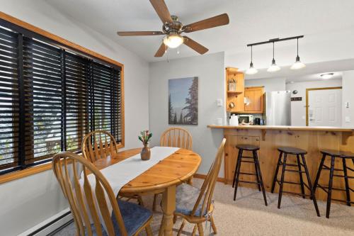 a kitchen and dining room with a wooden table and chairs at Snow Creek Village #37 By Bear Country in Sun Peaks