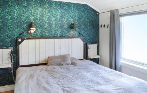 a bedroom with a bed with a green wall at Awesome Home In Dalar With House Sea View in Dalarö