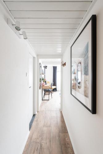 a hallway with white walls and a large picture on the wall at Penzion Mezi buky in Chřibská