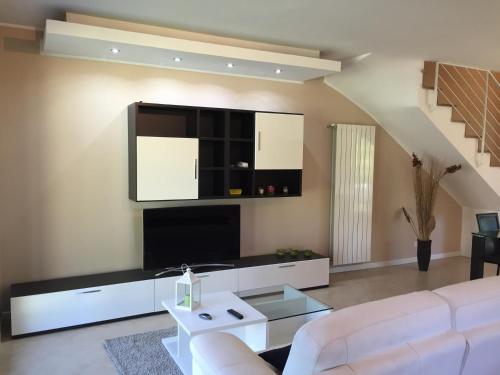 a living room with a white couch and a tv at Luxury Villa Park in Nepi