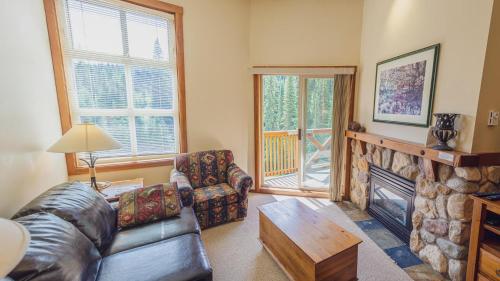 a living room with a couch and a fireplace at Fireside Lodge #419 By Bear Country in Sun Peaks