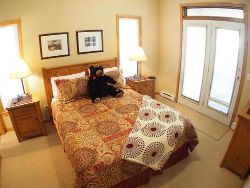 a teddy bear sitting on a bed in a bedroom at Crystal Forest #53 By Bear Country in Sun Peaks