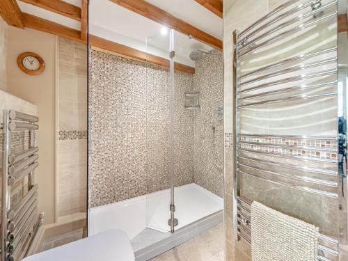ein Bad mit einer Dusche und einer Glasduschkabine in der Unterkunft Tan Y Castell Cottage in Lampeter-Velfrey