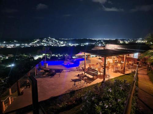 a patio with tables and chairs at night at Pousada Terraço Guarapari in Guarapari