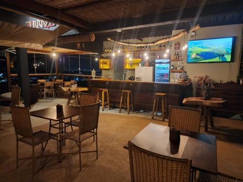 a restaurant with tables and chairs and a bar at Pousada Terraço Guarapari in Guarapari