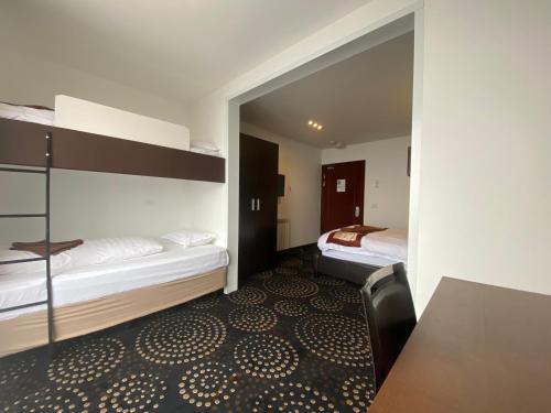 a room with two beds and a desk and a table at Duck Inn Mt Buller in Mount Buller