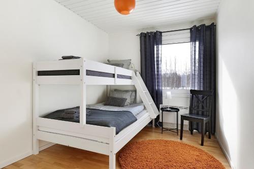 a white bunk bed in a room with a window at Guestly Homes - 3BR Seaside Luxury Villa in Piteå