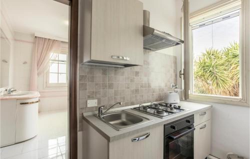 a kitchen with a sink and a stove and a window at Awesome Apartment In Vittoria With House Sea View in Vittoria