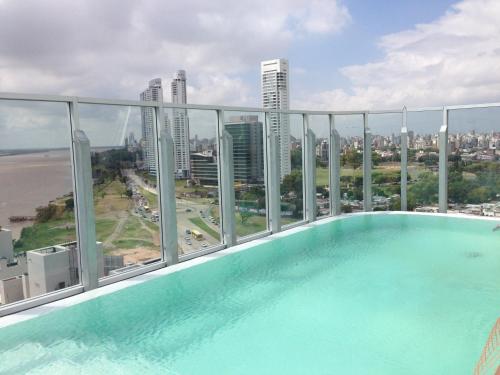 una piscina en la azotea de un edificio con ciudad en Puerto Norte Design Hotel en Rosario