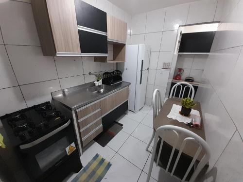 una pequeña cocina con fregadero y mesa en FLAT FAMILIAR com garagem até 5 pessoas, en Campina Grande