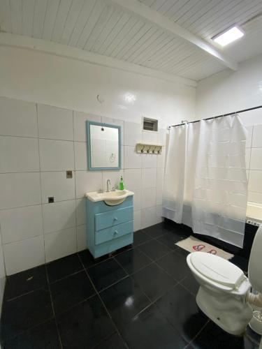 La salle de bains est pourvue de toilettes, d'un lavabo et d'un miroir. dans l'établissement Hospedaje El Tucan, à Puerto Iguazú