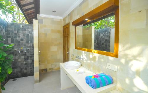 bagno con lavandino, servizi igienici e specchio di The Haven a Gili Trawangan