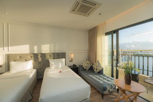 a hotel room with two beds and a balcony at Dana Pearl Bay in Danang