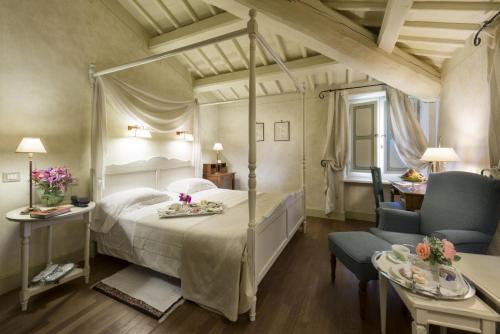 a bedroom with a canopy bed and a chair at Posta Donini 1579 - UNA Esperienze in San Martino in Campo
