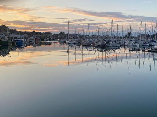 a marina with boats in the water at sunset at Holiday Home in Normandy near Sandy Beaches in Néville-sur-Mer
