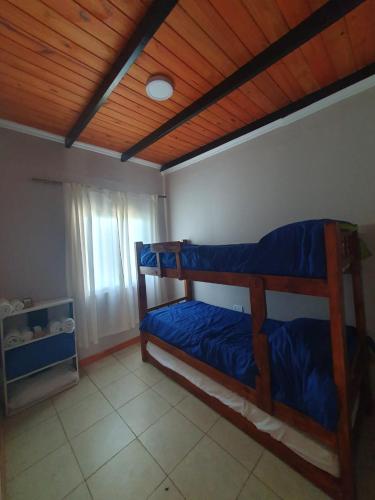 a bedroom with two bunk beds and a wooden ceiling at ALTOS DE LA CAÑADA in Albardón