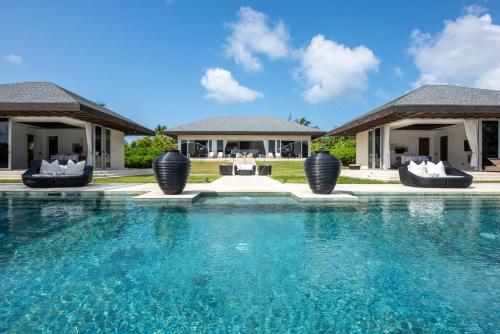 a swimming pool in front of a villa at Ananda House estate in Governorʼs Harbour