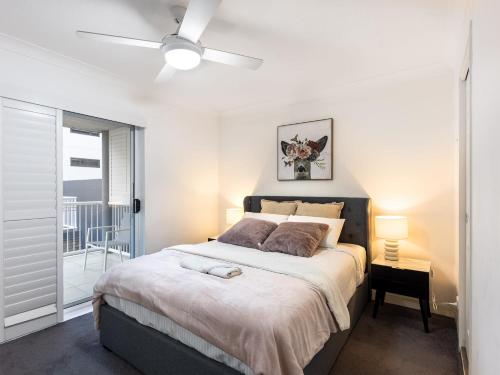a bedroom with a large bed with a ceiling fan at Spacious Newly Furnished 2bed Apartment in South Brisbane in Brisbane