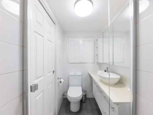 a white bathroom with a toilet and a sink at Spacious Newly Furnished 2bed Apartment in South Brisbane in Brisbane