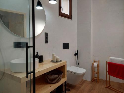 Un baño con lavabo, inodoro y espejo. en Apartamento Ricardo, en Carnota