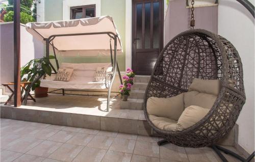 Zakučac的住宿－奧米甚普特博爾卡度假屋，一张藤椅,坐在门廊上,配有床