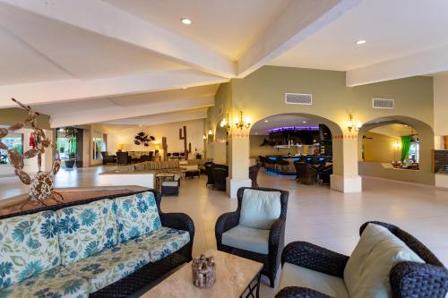 a lobby with a couch and chairs and a bar at Posada Real Los Cabos in San José del Cabo