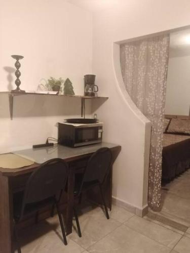 a room with a table with chairs and a microwave at Apartamento zona hotelera #6 planta alta in Mexicali