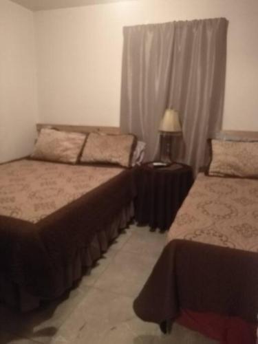 a bedroom with two beds and a lamp on a table at Apartamento zona hotelera #6 planta alta in Mexicali