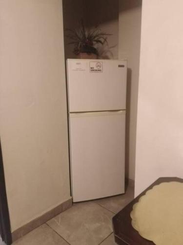 a white refrigerator in a corner of a room at Apartamento zona hotelera #6 planta alta in Mexicali