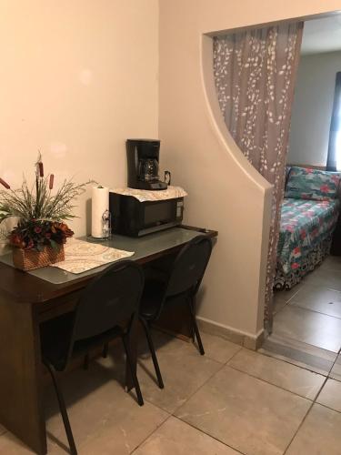 Zimmer mit einem Schreibtisch, einer Mikrowelle und einem Bett. in der Unterkunft Apartamento zona hotelera #6 planta alta in Mexicali
