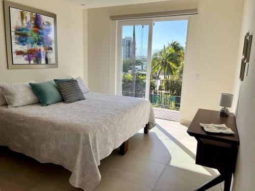 1 dormitorio con cama y ventana grande en Beautiful 3BR Condo with amazing rooftop terrace en Nuevo Vallarta 