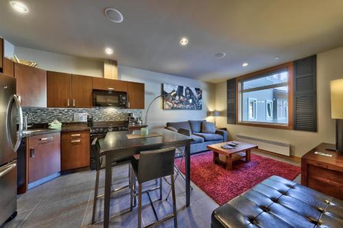 a kitchen and living room with a couch and a table at Kookaburra Lodge #202 By Bear Country in Sun Peaks