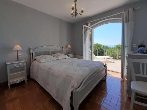 a bedroom with a bed and a large window at Maison Rayol-Canadel-sur-Mer, 5 pièces, 9 personnes - FR-1-308-142 in Rayol-Canadel-sur-Mer