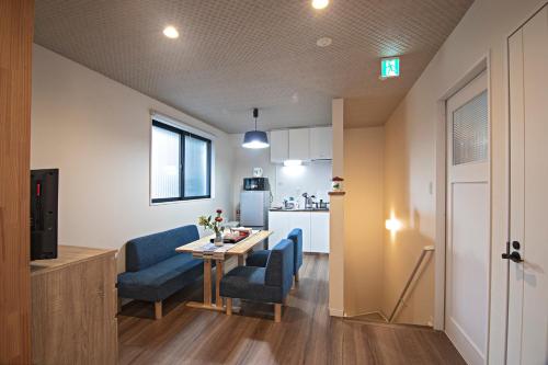 a living room with a table and chairs and a kitchen at -時の宿 二条- 二条城前駅 Toki Nijo RoomB in Kyoto