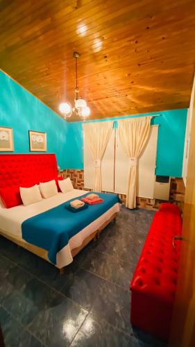 a bedroom with a large bed and a red couch at Tupungato Village in Tupungato