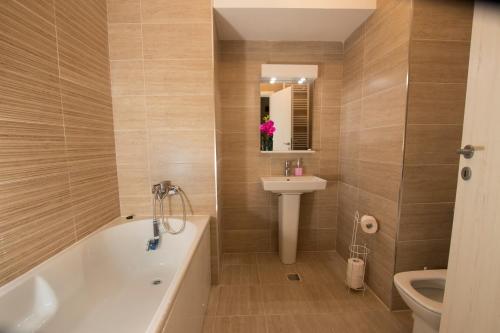 ein Badezimmer mit einer Badewanne, einem Waschbecken und einem WC in der Unterkunft Studio Moghioros rezidence 2 in Bukarest