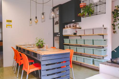 a dining room with a table and orange chairs at Hostel new way in Sao Paulo
