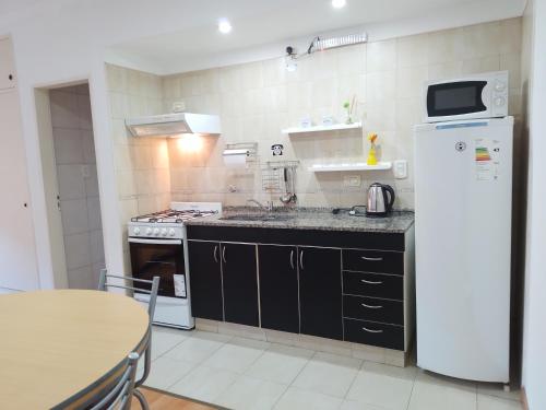 een kleine keuken met een koelkast en een tafel bij Mono ambiente en Colon in Colón