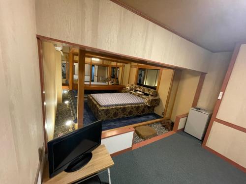 a view of a room with a bed and a television at ホテルあけぼの in Gamagōri