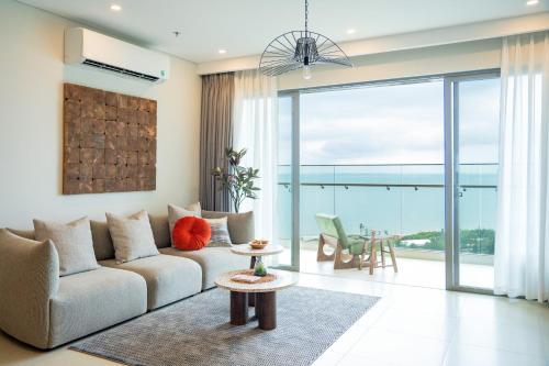 een woonkamer met een bank en een tafel bij THE SONG VŨNG TÀU - Five-Star Luxury Apartment - Căn Hộ Du Lịch 5 Sao Cạnh Biển in Vung Tau