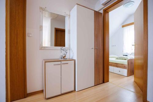a room with a mirror and a cabinet and a bedroom at Holiday home in Adlesici - Dolenjska & Bela krajina Unter- & Weißkrain 44970 in Adlešiči