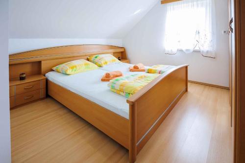a bedroom with a wooden bed with two shoes on it at Holiday home in Adlesici - Dolenjska & Bela krajina Unter- & Weißkrain 44970 in Adlešiči