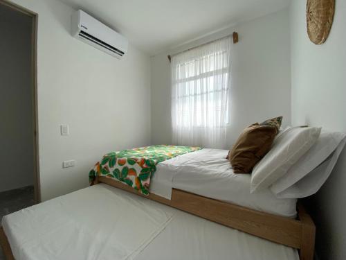 - une petite chambre avec un lit et une fenêtre dans l'établissement Apartamento en condominio con vista al mar, à San Bernardo del Viento