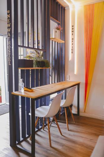 a table and chairs in a room with a book shelf at Hostel new way in Sao Paulo
