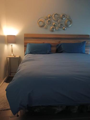 a bedroom with a large bed with blue sheets and a lamp at Nice & Near Downtown Nashville in Nashville