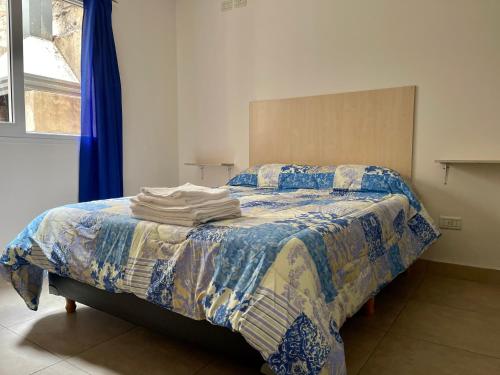 a bedroom with a bed with a quilt on it at Departamento temporal 2 Shopping in Villa Nueva