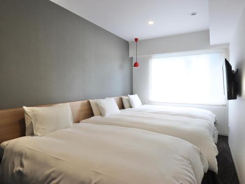 Кровать или кровати в номере HOTEL M's EST KYOTO STATION SOUTH
