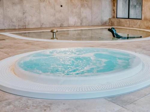 a hot tub with blue water in the middle of a room at Apartment with swimming pool, sauna, whirlpool, Dziwnów in Dziwnów