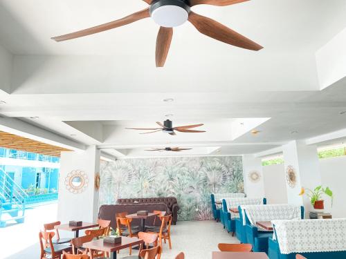 uma sala de jantar com mesas e cadeiras e uma ventoinha de tecto em Bohol Dolphin Bay Resort em Panglao City